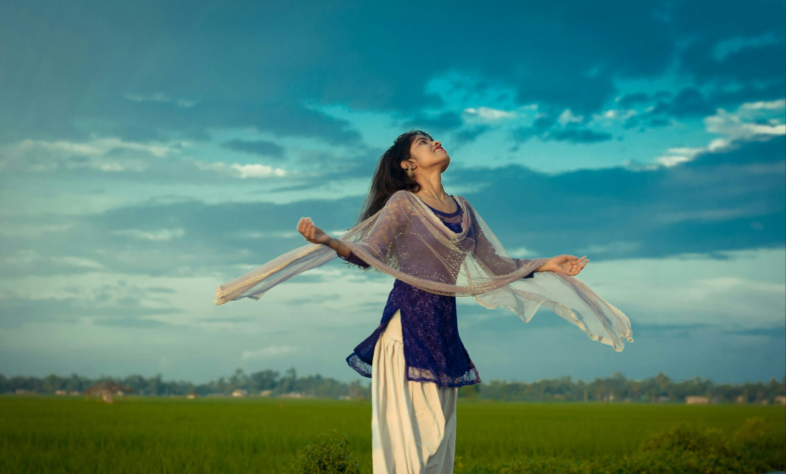  A woman spreading their arms and looking towards the sky